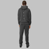 Back view of model. Full charcoal grey hemp tracksuit. Charcoal grey hemp hoodie with white detailing down the spine. Relaxed fit. Hemp active wear. 