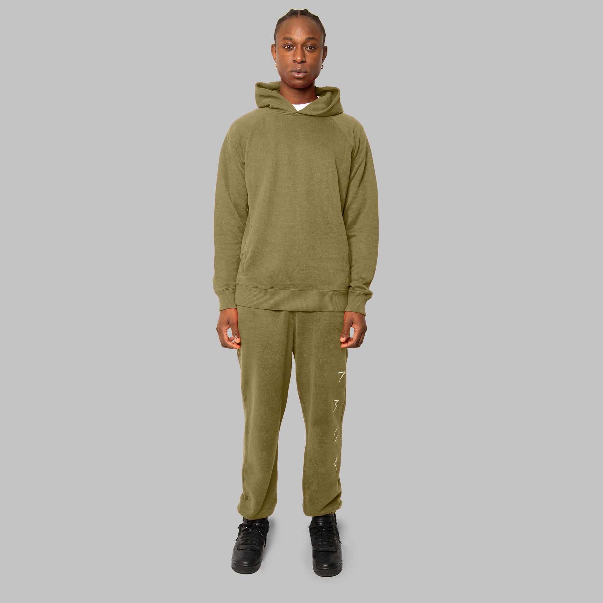 Full set olive hemp tracksuit. Olive hemp joggers and olive hemp hoodie. Front view of model. Sustainable street style. 