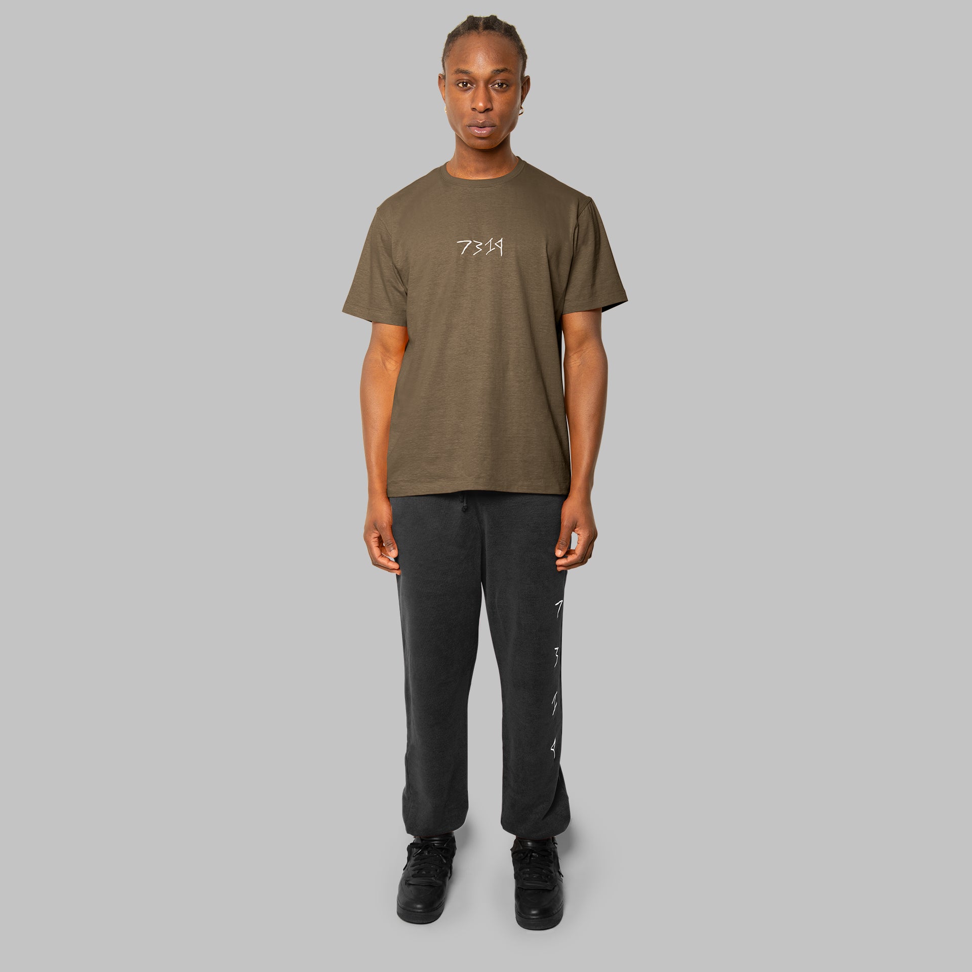 set of olive green hemp t-shirt and black hemp sweat pants. Front view of model. Sustainable fashion. 