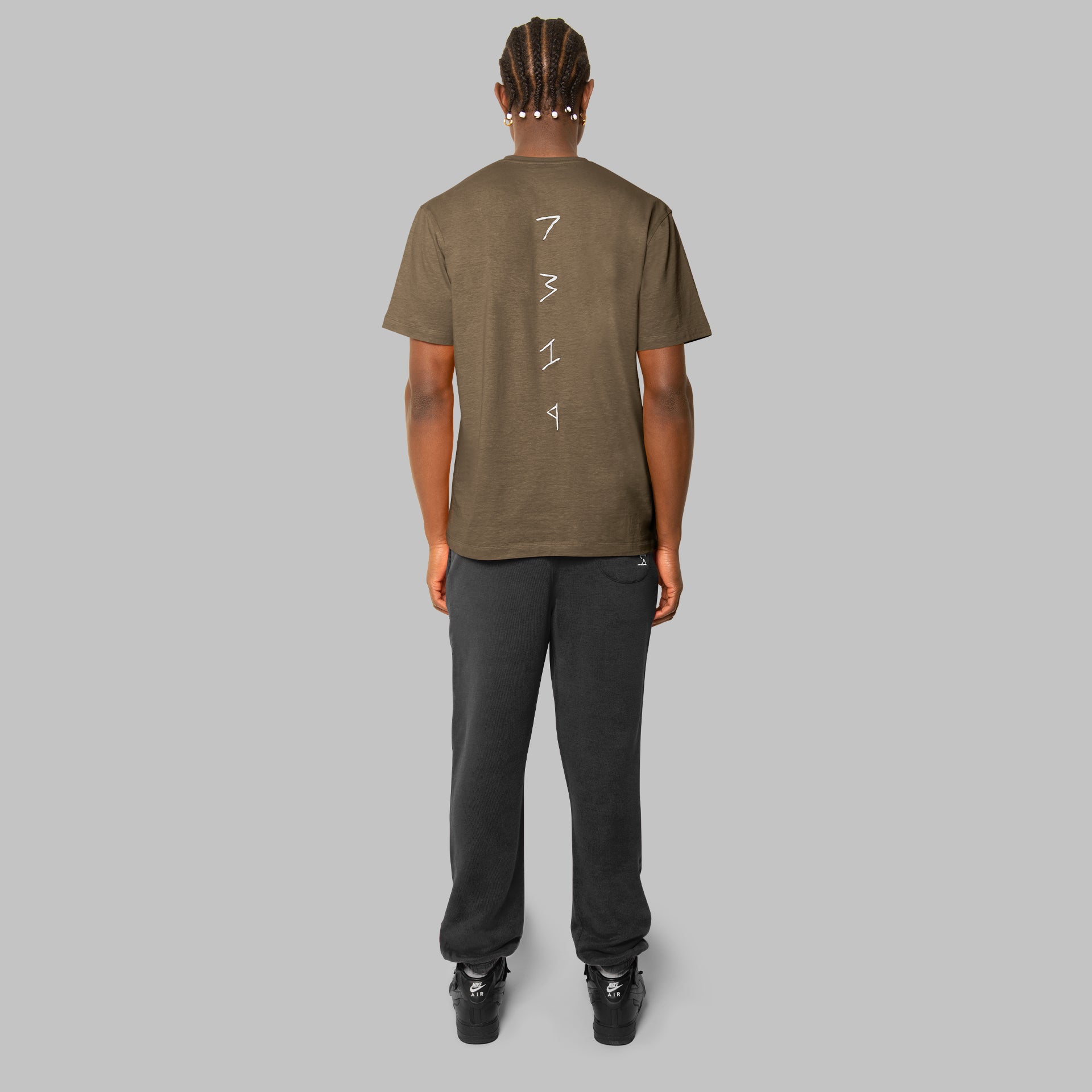 Olive green hemp t-shirt with black hemp joggers. White 7319 detailing down spine of hemp t-shirt. Ethical street style.