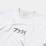blanc white hemp t-shirt with black 7319 embroidered logo across front. Front shot, zoomed to collar. Sustainable hemp label. Maison chanvre. Ethical street style. 