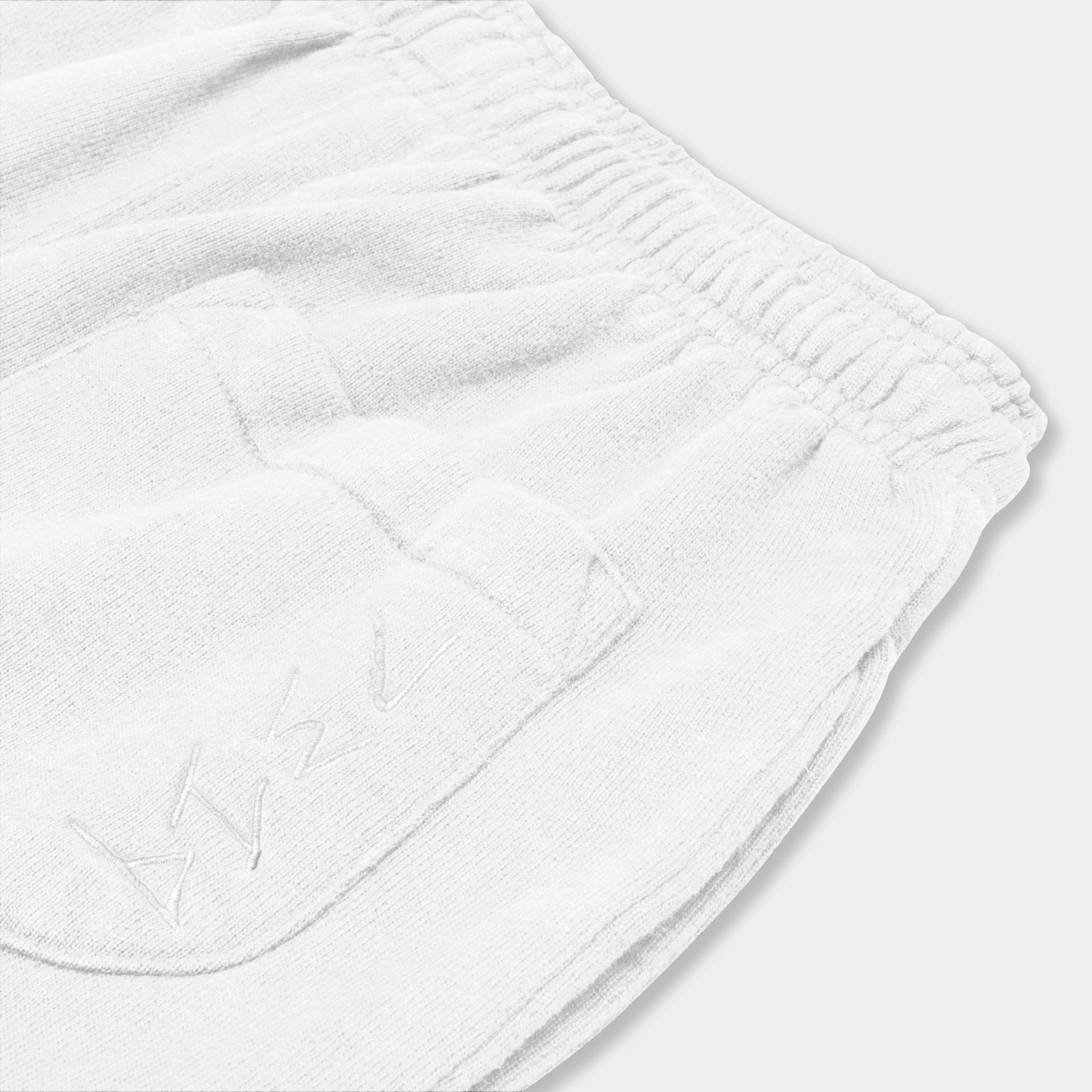 White hemp sweatpants. 7319 logo down side of back pocket. Zoomed shot of back pocket. Sustainable street wear. Natural organic fabric. 